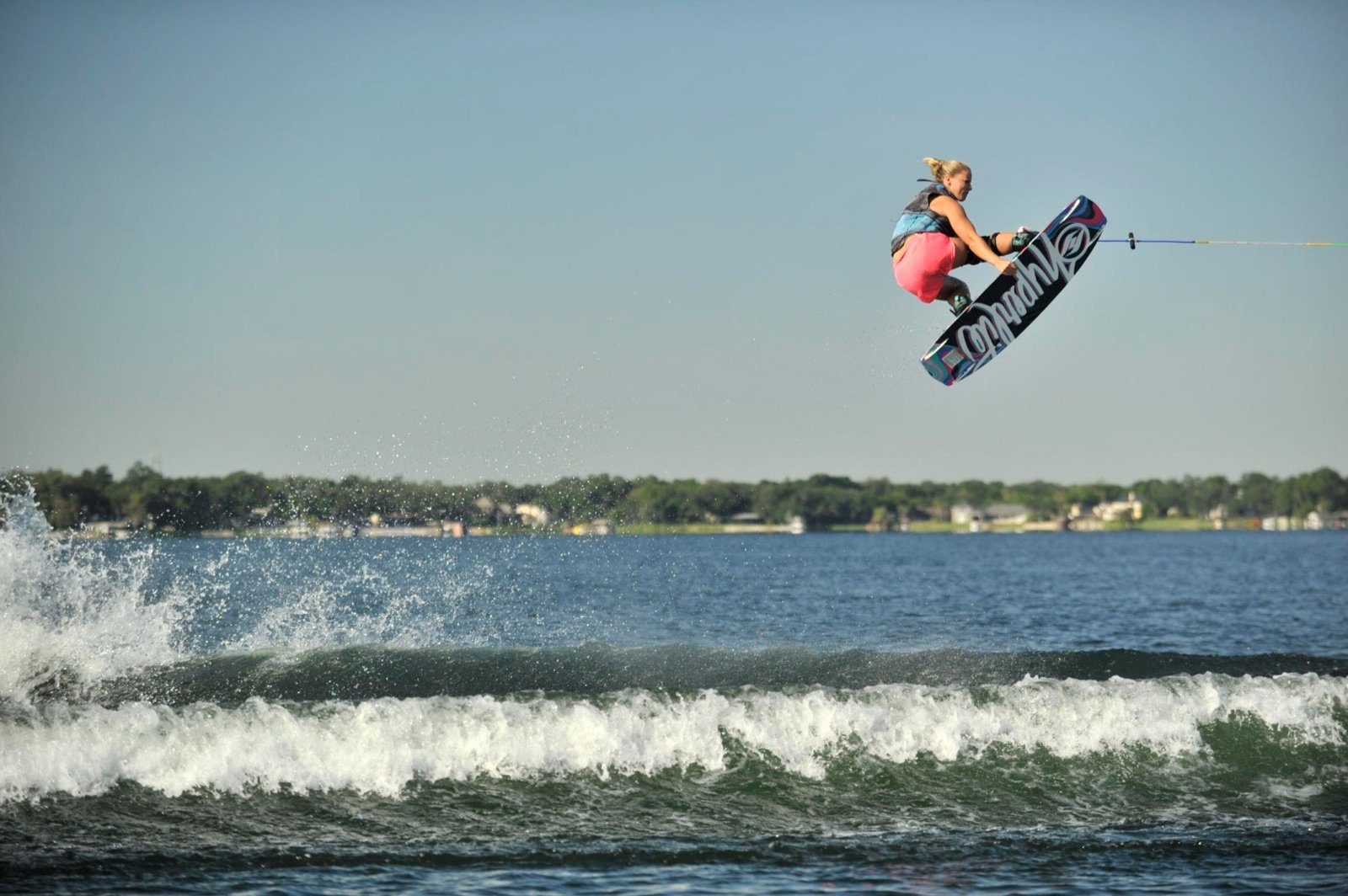 Charlotte Bryant boosting a big wakeboard air behind the boat