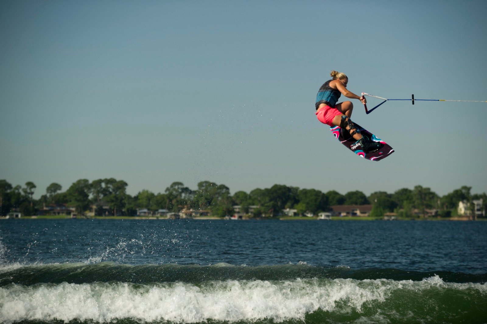 Charlotte Bryant grabbing the board mid-air on a Georgia lake